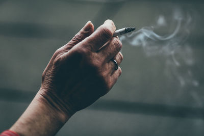 Close-up of hand holding cigarette