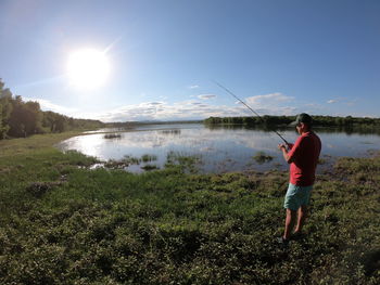 Woman standing on lake against sky