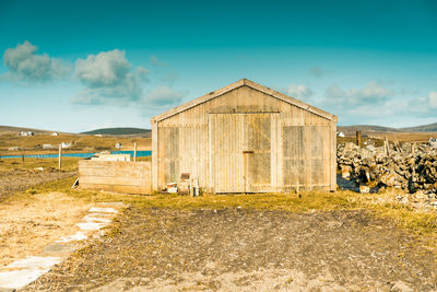 Barn on field against sky