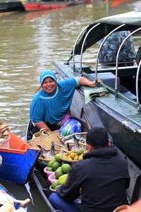 Portrait of smiling woman selling food on boat in lake