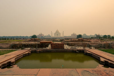 Golden gate bridge over lake in city against clear sky