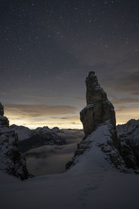 Scenic view of snowcapped mountains against sky at night