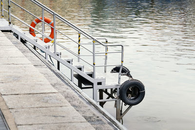 Iron stair or step by the water, descent to the water. little pier by lake or canal with cushion