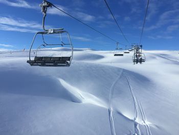 Scenic view of snow covered mountains against cloudy sky