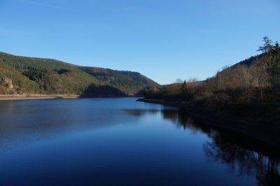 Scenic view of lake against clear blue sky