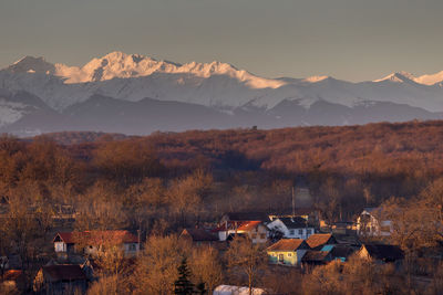 Scenic view of townscape and mountains against sky