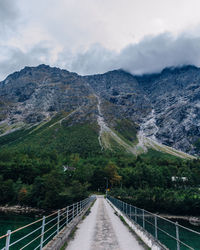 Road leading towards mountains against sky