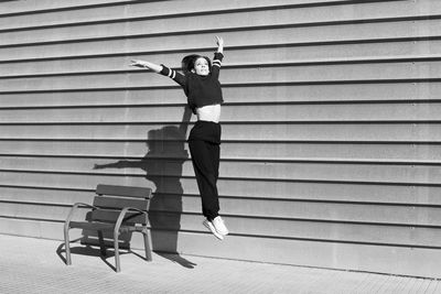 Full length of man with woman standing against wall