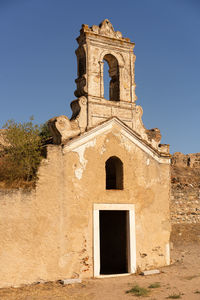 Low angle view of old building against clear blue sky