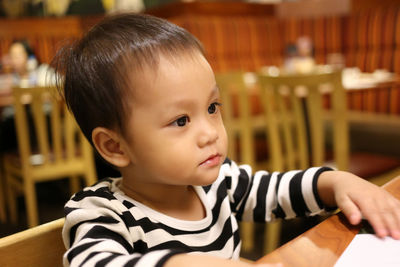Close-up of cute boy sitting at restaurant