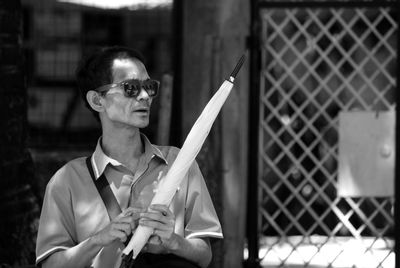 Portrait of a man wearing sunglasses with umbrella