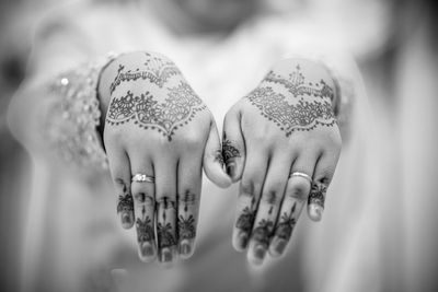 Midsection of bride showing henna tattoos on hands