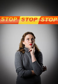 Portrait of woman standing against wall