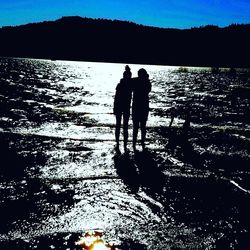 Silhouette of woman in pond at sunset