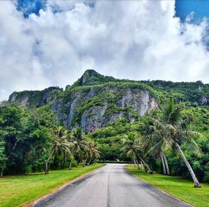 Road amidst trees against sky