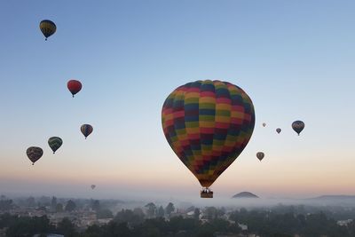 Hot air balloons against sky during sunset