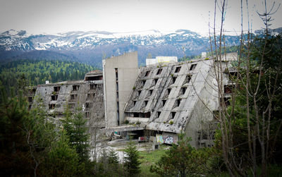 Buildings by mountain against sky