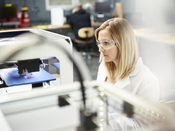 Female technician checking 3d printer