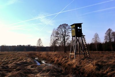 Lifeguard tower on field against sky