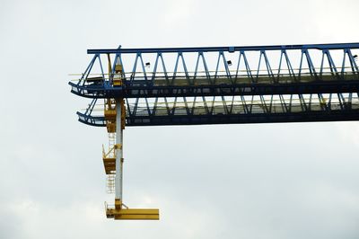 Low angle view of crane against sky