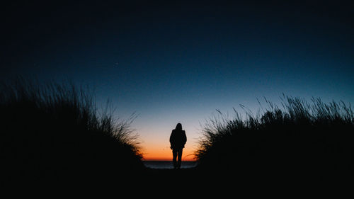 Silhouette woman standing against clear sky during sunset