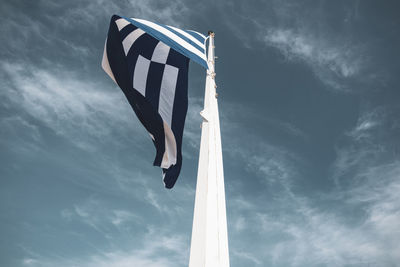 Low angle view of flag against blue sky