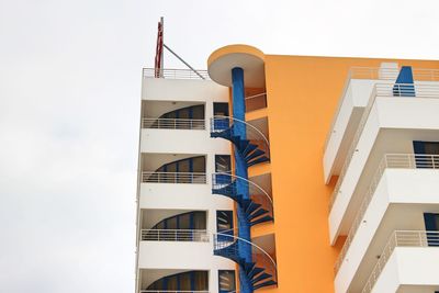 Low angle view of building with spiral stairs against sky