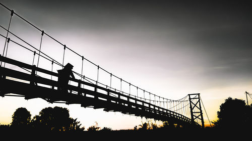 Low angle view of silhouette bridge against sky