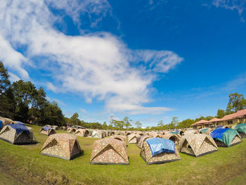 Panoramic view of houses and trees on field against sky