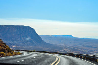 Road leading towards mountains against sky near arizona.