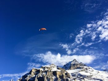 Low angle view of people on mountain against sky