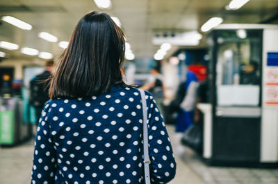 Young woman standing by railing