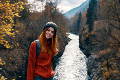 Young woman standing on snow covered land during autumn