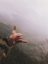 Midsection of person on mountain against sky