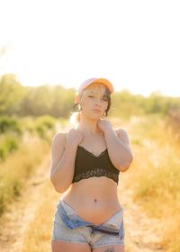 Portrait of young woman standing on field