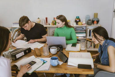 Young friends doing school assignment together at home