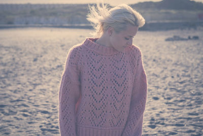 Young woman wearing sweater while looking away