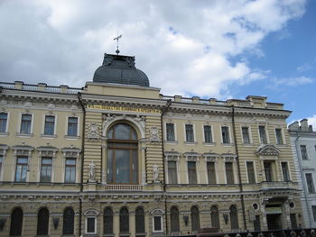 Low angle view of building against cloudy sky