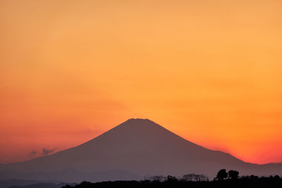 Scenic view of silhouette mountain against orange sky