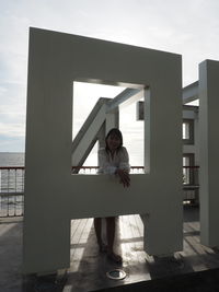 Full length of woman standing against built structure