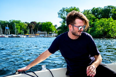 Young man in boat against plants