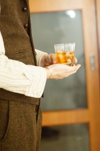 Midsection of woman holding drink on table