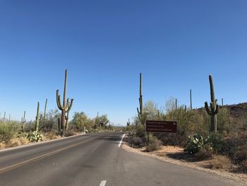 Country road against clear blue sky