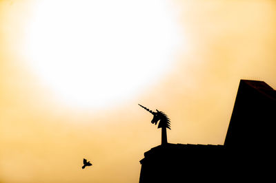 Low angle view of silhouette birds flying against sky during sunset