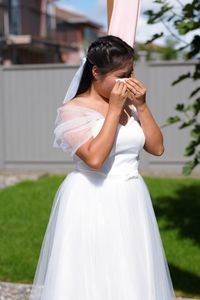 Side view of bride holding bouquet