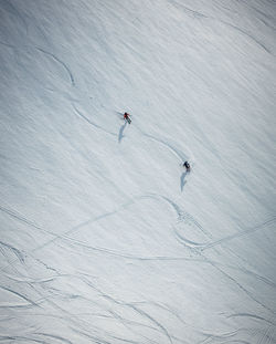 Two men skiing on snow in iceland from overhead angle