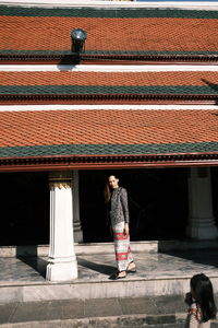 Rear view of man standing on roof of building