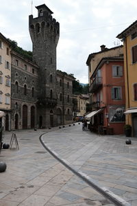 Street amidst buildings in town against sky