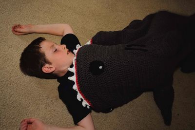 High angle view of boy lying on toy at home