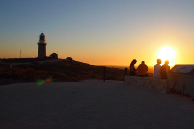 People on lighthouse at sunset